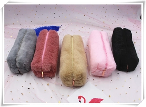 Macro detail of plush pencil pouches in five colors with metallic zippers and faux fur texture