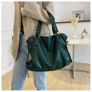 Close-up of deep green large capacity tote bag with vintage metal hardware for daily commute