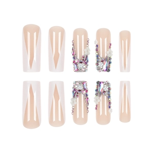 French tip press-on nails with white V-shapes, 3D flowers, and luxury rhinestones
