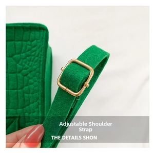 Detail of green crocodile texture shoulder strap with adjustable golden metal buckle