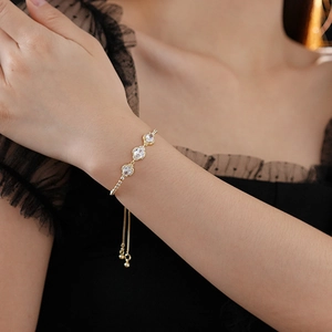 Detail of adjustable gold floral bracelet with zircon clovers worn on a wrist