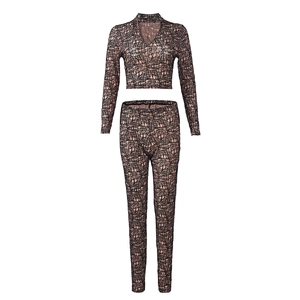 Detail of V-neck long sleeve crop top with black abstract mesh pattern on nude fabric