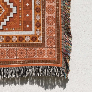 Close-up of geometric bohemian woven blanket showing texture and colorful tassels