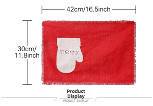 Detail of red linen Christmas placemat with merry embroidery and fringe edge 42x30cm