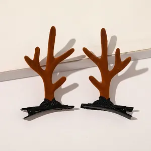 Detail view of brown plush reindeer antler hair clips on black metal alligator grips
