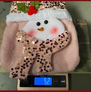 Detailed view of pink plush Christmas gift bag with sequined snowman weighing 52 grams