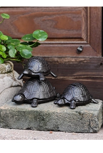 Three-piece set of cast iron turtle storage boxes with rustic textured shells on stones