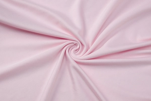 Detailed macro view of pink knitted fabric texture showing soft spiral pleated pattern