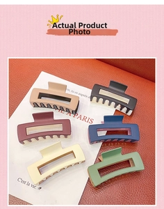 Macro view of rectangle matte hair claws in various macaron colors on leather background