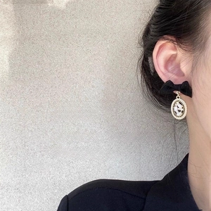 Gros plan de boucles d'oreilles nœud noir avec pendentif en cristal sur le mannequin