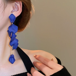 Detail view of long blue petal tassel earrings on a model showing elegant drape style