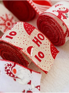 Close-up of red and white Christmas ribbon with Ho Ho Ho, snowman, and snowflake prints