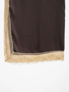 Detailed close-up of dark brown satin fabric with intricate beige lace trim edging