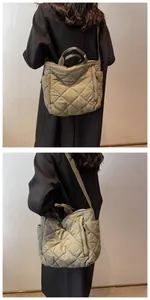 Macro view of olive green quilted nylon tote bag showing double handles and side pockets
