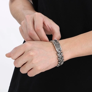 Detail eines silbernen Titanstahl-Armbands im Vintage-Stil mit Pfeilknochen-Glieder-Design