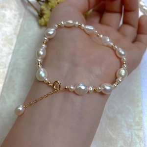 Macro view of baroque pearls with 14K gold plated clasp and adjustable chain on wrist
