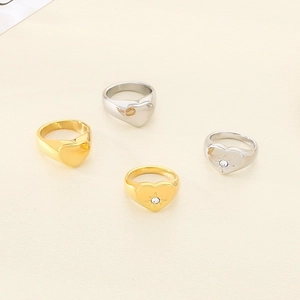 Detail of four heart-shaped 18K gold and silver plated rings with starburst zircon settings