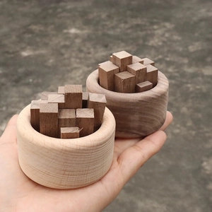 Diffuseurs d'huiles essentielles en bois clair et foncé tenus à la main avec texture nette