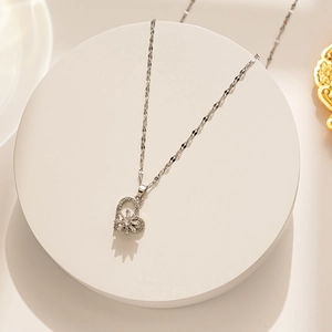 Detailed view of silver heart pendant with rotating snowflake crystal in titanium steel