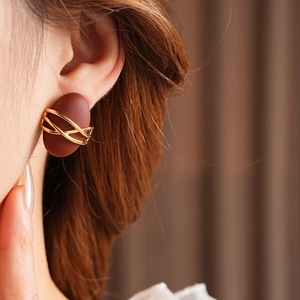 Detailed model shot of vintage oval earrings in deep reddish-brown with gold wire wrap