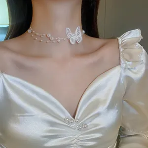 Detail of elegant lace butterfly necklace with pearls and multi-layer tassel design