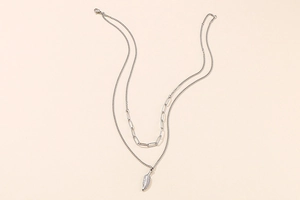 Detailed macro view of silver double-layered necklace featuring feather pendant and paperclip chain