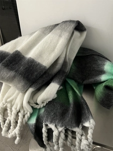 Detail shot of the thick gradient mohair texture and fringe on the plaid scarf