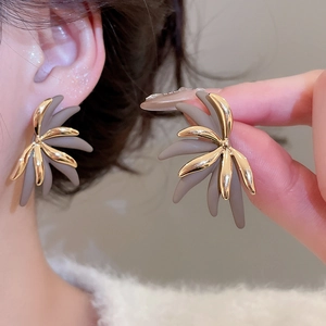Detail of 18k gold plated leaf-shaped earrings with layered metallic and matte texture