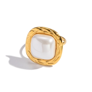 Macro view of gold vintage ring featuring a square pearl with a woven rope metal border