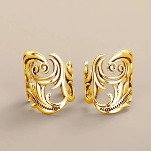 Close-up of vintage hollowed gold ear cuffs with intricate floral filigree textures