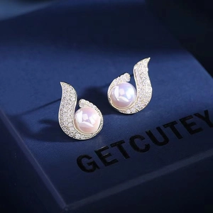 Detailed macro of water-drop pearl earrings with gold-plated micro-pave setting