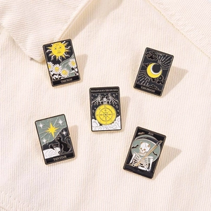 Détail de 5 broches tarot en émail avec crâne, lune et soleil sur du velours