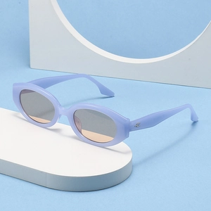 Retro lavender oval sunglasses with light amber lenses on a geometric display stand