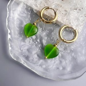 Close-up of gold 18K plated stainless steel hoop earrings with green cat eye heart pendant