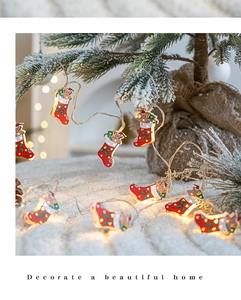 Close-up of LED Christmas stocking lights on a snowy tree branch with warm glow