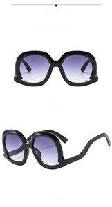 Front and 45-degree side views of black oversized sunglasses with gradient lenses