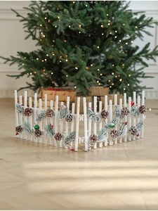 Detail of white snowy wooden fence with pine cones for Christmas tree base decoration