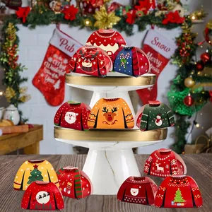 Christmas sweater shaped gift boxes with festive patterns on an elegant display tray
