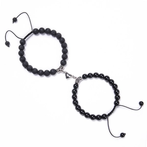 Detail of heart magnetic charms on black volcanic stone beaded bracelets for couples