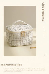Detail of tweed makeup bag showing woven texture, dual gold zippers, and sturdy handle