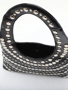 Close-up of punk style black hobo bag with silver rivet studs and crescent shape