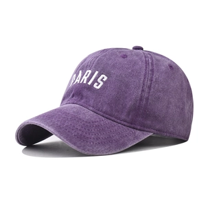 Detailed close-up of purple washed cotton baseball cap featuring white PARIS embroidery