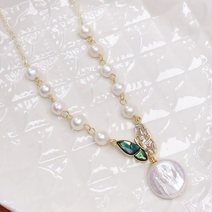 Close-up of fresh water pearl necklace with butterfly shell pendant and baroque drop
