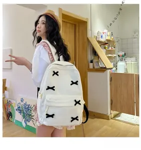 Detail of white corduroy backpack with black crisscross ribbons and front pocket