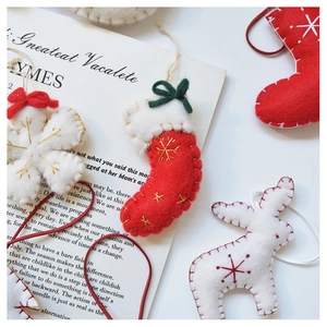 Detailed view of handmade wool felt Christmas ornaments with embroidery and stitching