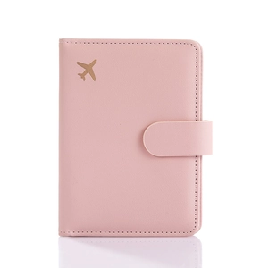 Pink leather passport holder with gold airplane logo and secure snap button closure