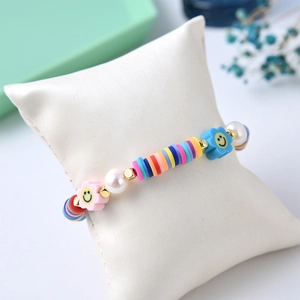 Makro-Detail des handgefertigten Regenbogen-Heishi-Armbands mit Smileys und Perlen