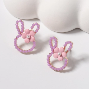 Detail of bunny stud earrings featuring purple beads and a pink flower with pearl accent