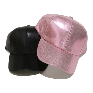 Close-up of metallic pink and black faux leather baseball caps with reinforced stitching