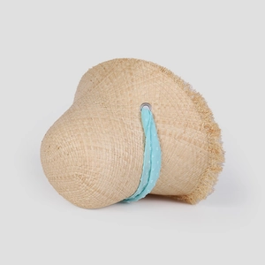 Detailed close-up of straw sun hat with sky blue polka dot ribbon and frayed edge